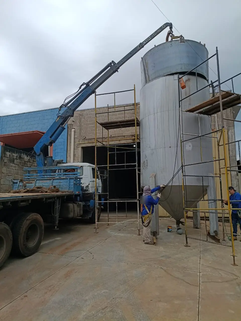 Caminhão munck da Zana içando silo de inox em indústria na região de Catanduva